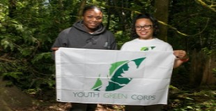 Two people holding a Youth Green Corps flag
