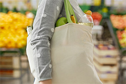 A woman carrying groceries in cloth bag.