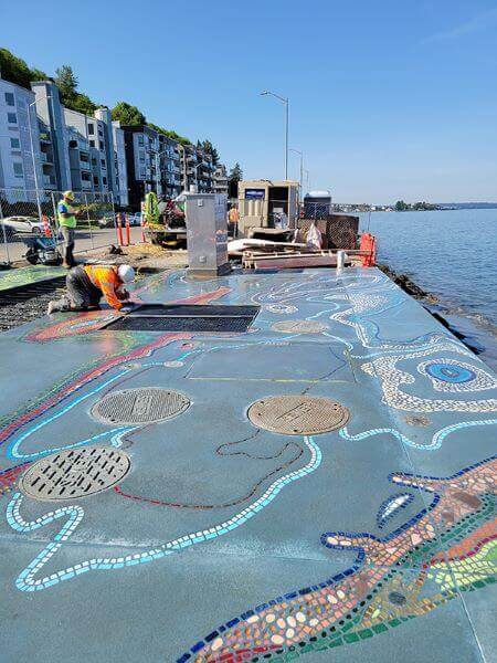 Workers putting finishing touches on artwork, looking west.