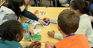 Children in a classroom engaging in a group activity at a table