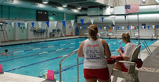 2 lifeguards overseeing an indoor pool