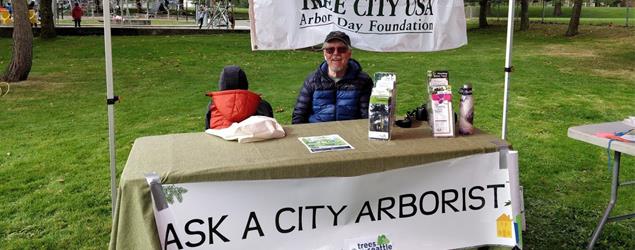 Tree volunteer answering questions at a public gathering desk