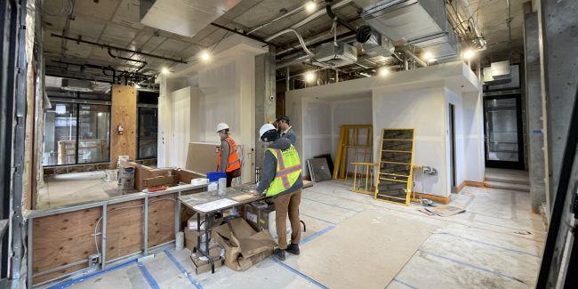 Construction workers building a new counter in an empty building