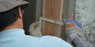 An inspector measuring part of a doorway