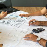 People working on a printed architectural floorplan