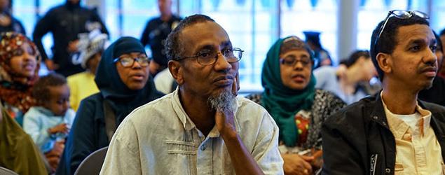 Image of several individuals attending an event and listening attentively
