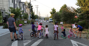 Children getting ready to ride bicycles on residential street