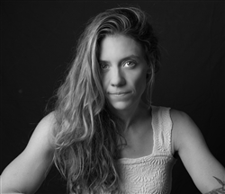 A grayscale portrait of Cecelia looking into the camera in front of a dark background.